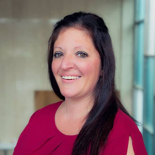 Smiling woman in a red blouse, indoors.