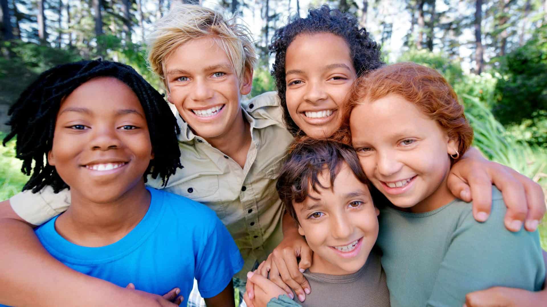 Smiling diverse group of children outdoors.