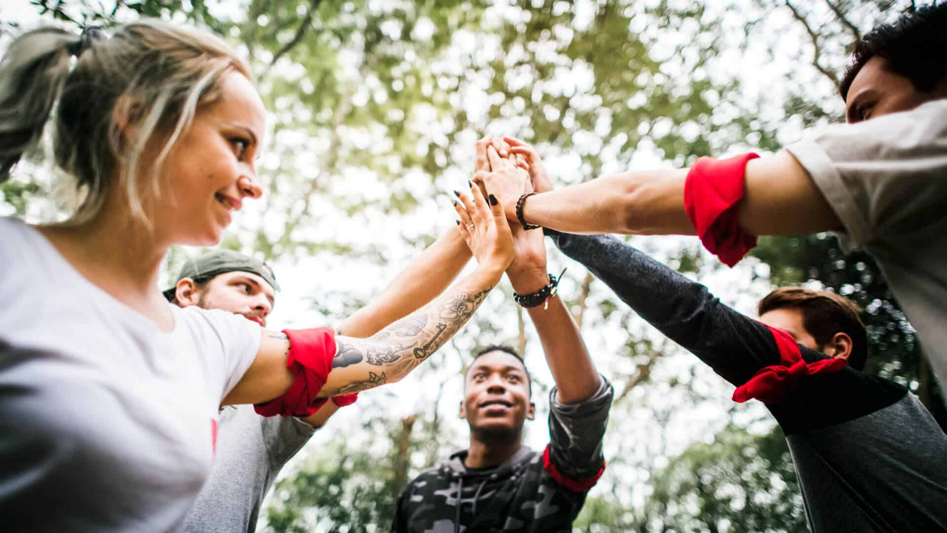 Team celebrates with high-five outdoors.