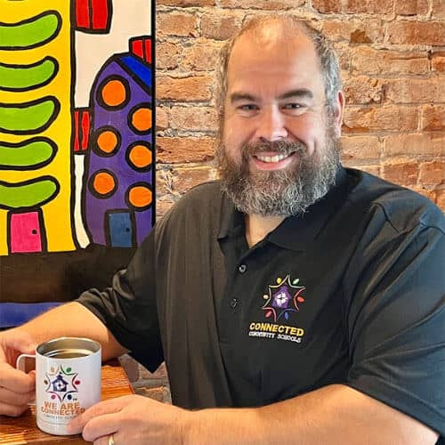Smiling man holding a mug in a cafe.
