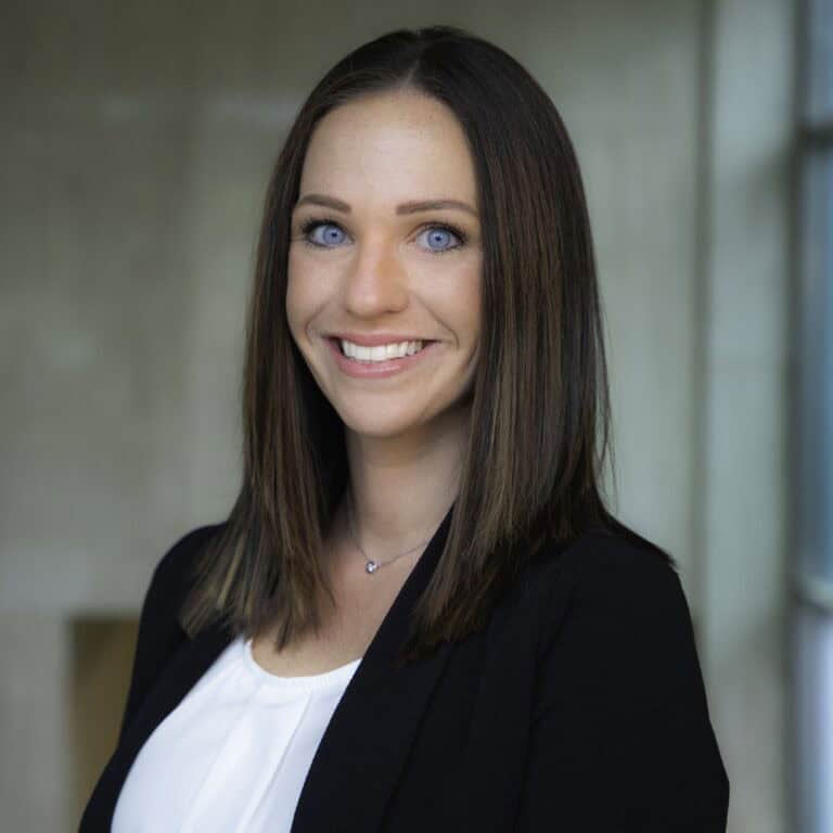 Smiling woman in professional attire indoors.